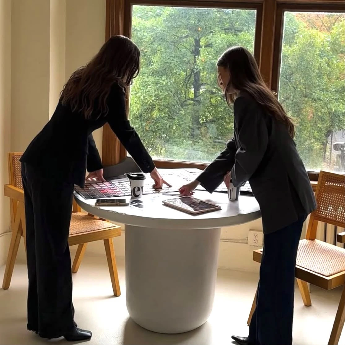 Two practitioners reviewing materials around a table